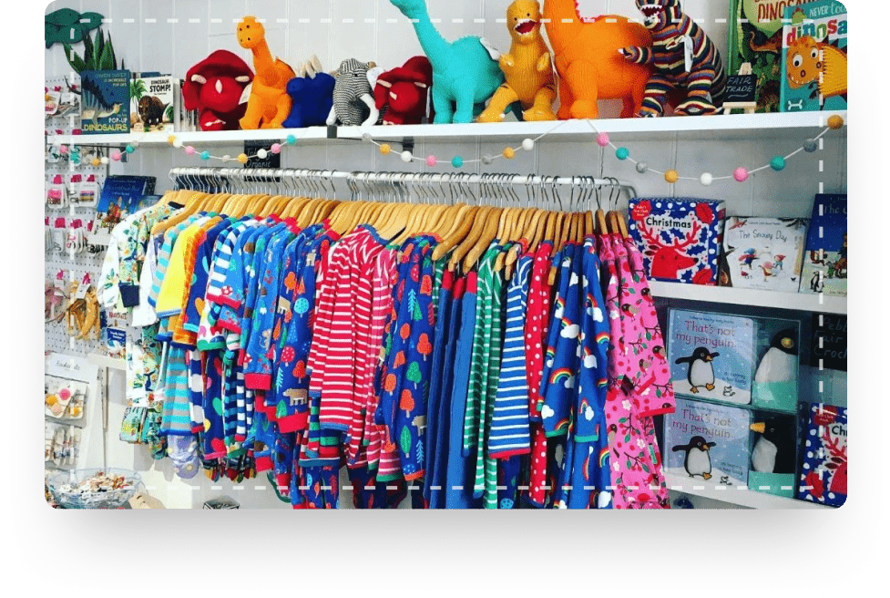 A colourful display rail of Toby Tiger and Blade & Rose children's clothes at Ebb & Flow Kids Toy Shop