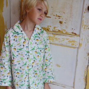 Young boy wearing 100% cotton PJ's in dinosaur print by Powell Craft. Shop online with Ebb & Flow Kids