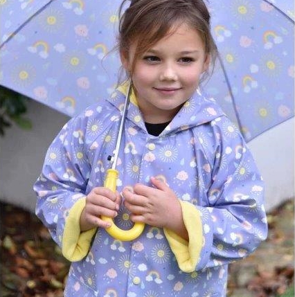 Little girl wearing our sunshine design raincoat by Powell Craft. Shop online with Ebb & Flow Kids