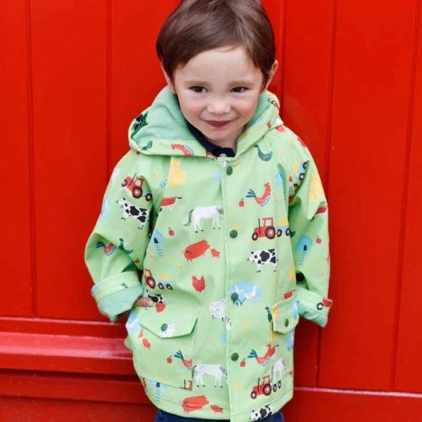 Little boy wearing Powell Craft's Farmyard Raincoat. Buy online with Ebb & Flow Kids.